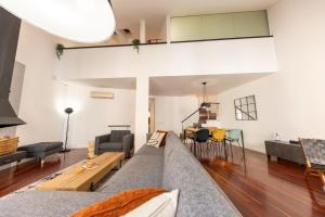 a living room with a couch and a table at Bravissimo Cort Reial Palau, Duplex penthouse in Girona