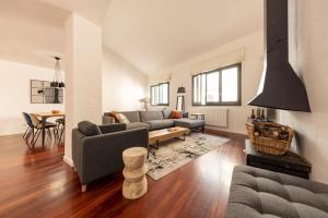 a living room with a couch and a table at Bravissimo Cort Reial Palau, Duplex penthouse in Girona