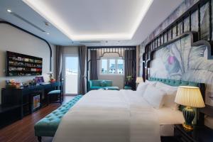 ein Hotelzimmer mit einem großen Bett und einem Schreibtisch in der Unterkunft PALAGO BOUTIQUE HOTEL in Hanoi