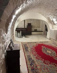 sala de estar con alfombra roja y mesa en Le segrete del Notaio en Conversano