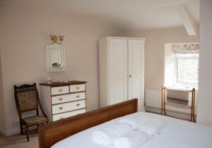 a bedroom with a bed and a dresser and a window at Dalesmoor in Reeth