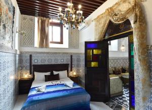 a bedroom with a bed and a chandelier at Dar Aya Fes in Fez