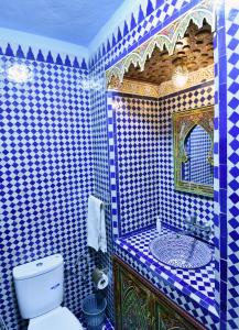 フェズにあるDar Aya Fesの青と白のタイル張りの壁のバスルーム、トイレ