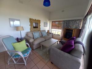 a living room with a couch and chairs and a fireplace at Ocean rush Seagull in Zinkwazi Beach