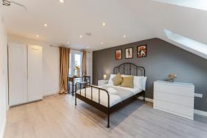 a bedroom with a bed and a dresser at Perivale Studio Apartments in Perivale