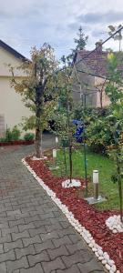 einen Garten mit zwei Bäumen und einem Ziegelsteinweg in der Unterkunft Soba Luić in Županja