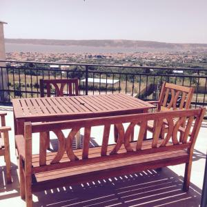 a wooden bench sitting on top of a balcony at Apartments and rooms Niki 2 in Kaštela