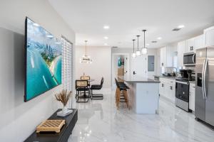 a kitchen and dining room with white cabinets and a table at 4 Bedroom Holiday Retreat BBQ Marketplace in Miami