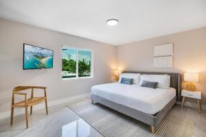 a bedroom with a bed and a chair and a window at 4 Bedroom Holiday Retreat BBQ Marketplace in Miami