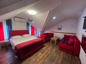 um quarto com uma cama e 2 cadeiras vermelhas em Prenoćište SAMIR em Gradačac