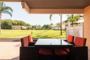 Apartamento Monte Laguna في فيلامورا: طاولة وكراسي على فناء مطل على حديقة