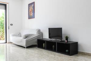 un soggiorno con sedia bianca e TV di Apulian Sunset a Monopoli