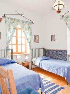een slaapkamer met 2 bedden en een raam bij Somogy Kertje Üdülőfalu és Étterem in Bonnya