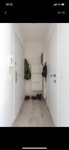 a white room with a hallway with shoes on the floor at Charmante studio op toplocatie aan Meir. in Antwerp