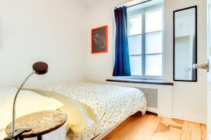 a bedroom with a bed with a table and a window at La Maison Grenier La Résidence Beauport in Quebec City