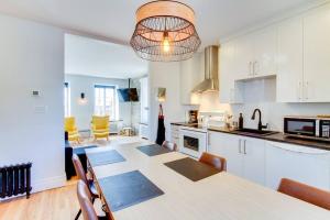 een keuken en eetkamer met een tafel en stoelen bij La Maison Grenier La Résidence Beauport in Québec