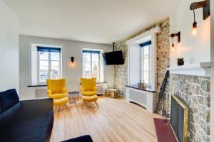 a living room with two yellow chairs and a fireplace at La Maison Grenier La Résidence Beauport in Quebec City