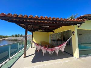 een hangmat op het balkon van een huis bij Casa beira rio-mar in Barra de São Miguel