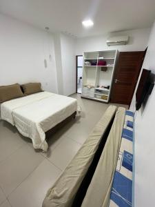 een slaapkamer met een bed en een tv. bij Casa beira rio-mar in Barra de São Miguel