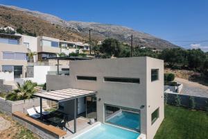 una casa con una piscina encima en New Modern Villa Domus Rodia with private pool & BBQ, 4km from nearest beach, en Marioú