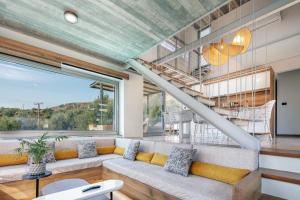 a living room with a couch and a large window at New Stylish Villa Domus Rodia with private pool & BBQ, 4km from Plakias beach in Marioú