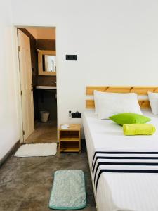 Mahagedara Dickwella في ديكويلا تين: غرفة نوم بسرير ابيض كبير مع مخدات خضراء