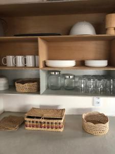 une étagère avec des bols, des assiettes et des paniers dans l'établissement CASA BRANCA NA PRAIA, à Icapuí