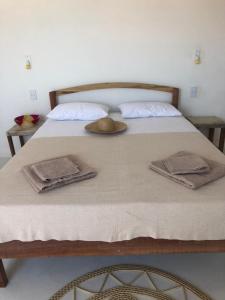 Una cama con toallas y almohadas. en CASA BRANCA NA PRAIA en Icapuí