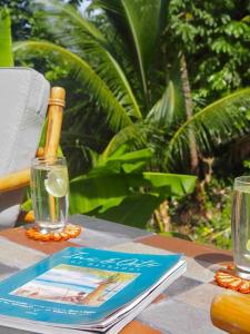 a table with a book and two glasses on it at Little Diamond, Wooden Jungle House. Bathsheba. in Saint Joseph