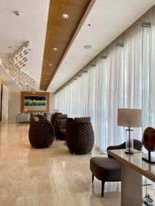 a lobby with chairs and a table in a building at Pasay Condotel with Massage Chair and PS4- Stellar Suites in Manila