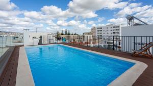 a swimming pool on the roof of a building at Brand New 2 BDR Flat W/Rooftop Pool by LovelyStay in Olhão