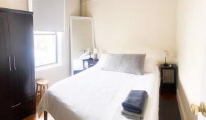 een slaapkamer met een wit bed met een blauwe handdoek erop bij 2 Bedrooms Entire Beautiful Apt in Williamsburg! in Brooklyn