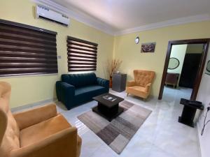 a living room with a couch and two chairs at MOK Apartments & Suites in Lagos
