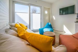 a living room with a couch with yellow pillows at Surf and Turf Apartment in Hanko in Hanko