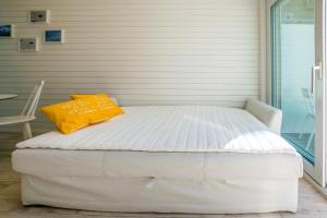 a bed with a yellow pillow on top of it at Surf and Turf Apartment in Hanko in Hanko