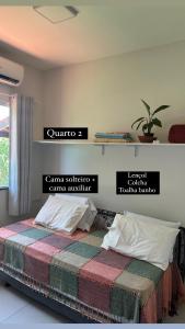 a bedroom with a bed with a colorful blanket at Cantinho do aconchego de Arembepe in Camaçari