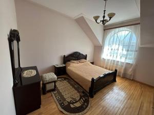 1 dormitorio con cama, mesa y ventana en Red House en Ijevan