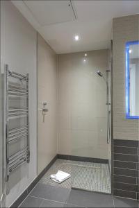 baño con ducha y puerta de cristal en Grays Inn by Q Apartments, en Londres
