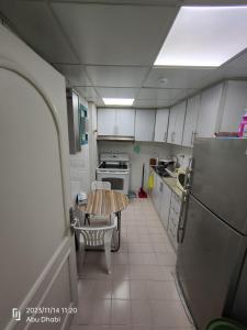 a small kitchen with a table and a refrigerator at Master room 1, Couples should be married in Abu Dhabi
