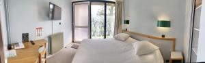 - une chambre avec un lit blanc et une fenêtre dans l'établissement Le Keréden - Breizh Ecolodge Hôtel, à Locarn
