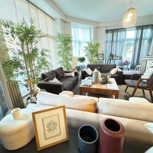 a large living room with couches and a table at Cit'Hotel Les Alizes in Dinard