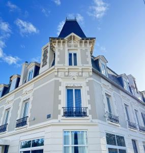 a building with a tower on top of it at Cit'Hotel Les Alizes in Dinard