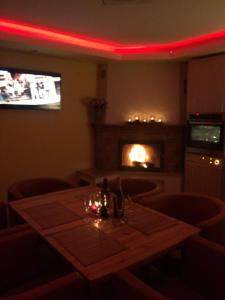 a dining room with a table and a fireplace at Pie ābeles in Ventspils