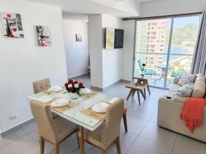 a living room with a dining table and a couch at Apartamento para estrenar Ambar Roca - Bedviajes in Santa Marta