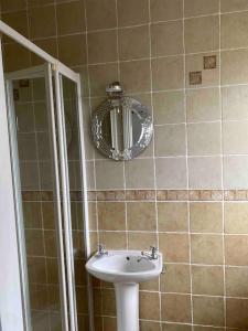 een badkamer met een wastafel en een spiegel bij Cois Locha in Glenbeigh