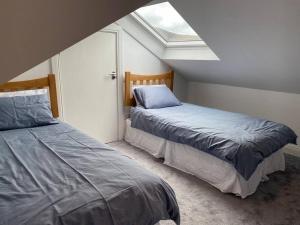 a bedroom with two beds and a skylight at Cois Locha in Glenbeigh