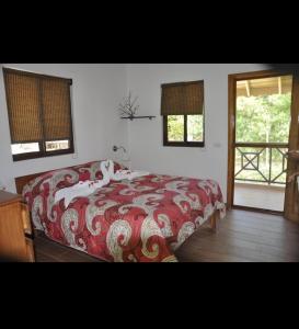 - une chambre dotée d'un lit avec une couverture rouge et blanche dans l'établissement Hotel Piedra Marron, à Las Terrenas