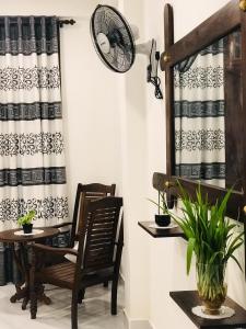 a room with a table and chairs and a fan at Ibeeza Motel in Dickwella