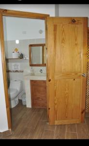 La salle de bains est pourvue de toilettes et d'une porte en bois. dans l'établissement Hotel Piedra Marron, à Las Terrenas