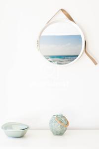 a mirror on a wall with a bowl and a vase at Sunset View La Tejita, by Nivariahost in Granadilla de Abona